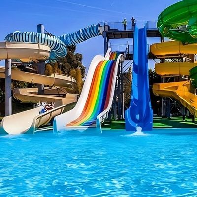 Niños en la piscina en el suelo pasear por el tobogán de fibra de vidrio para el parque acuático